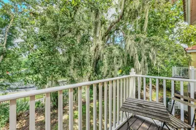 a wooden bench sitting on a porch next to a tree at Orlando Villa 6230: A Stylish Family Retreat Near Disney in Kissimmee