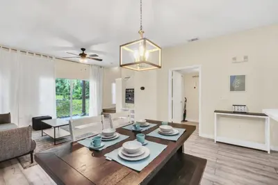 a living room with a table and a dining room at Orlando Villa 6230: A Stylish Family Retreat Near Disney in Kissimmee