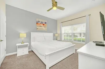 a white bedroom with a white bed and a window at Rent Orlando Villa 6235: Perfect Luxury Villa by Disney in Kissimmee