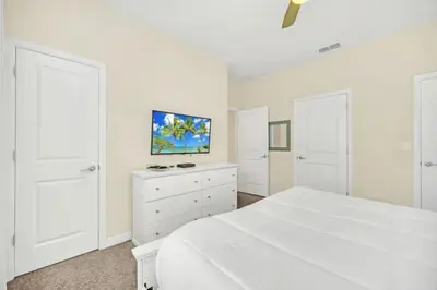 a white bedroom with a white bed and a white dresser at Rent Orlando Villa 6235: Perfect Luxury Villa by Disney in Kissimmee
