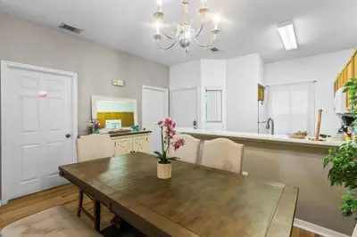 a kitchen and dining room with a wooden table at Orlando Villa 6244: Luxury 5-Star Villa Minutes from Disney in Kissimmee