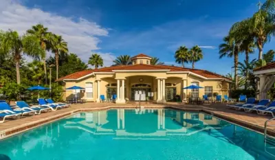 a house with a pool with chairs and palm trees at Orlando Villa 6244: Luxury 5-Star Villa Minutes from Disney in Kissimmee
