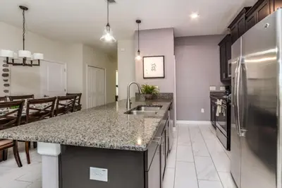 a kitchen with a sink and a stainless steel refrigerator at Orlando Villa 6243: The Best Orlando Getaway at Storey Lake in Kissimmee