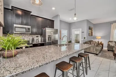 a kitchen with a large counter top and bar stools at Orlando Villa 6243: The Best Orlando Getaway at Storey Lake in Kissimmee