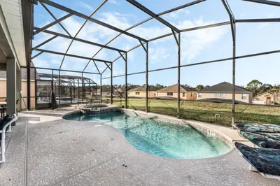 an indoor swimming pool with a clear glass enclosure at Orlando Villa 6245: Dream Holiday Villa in Emerald Island in Kissimmee