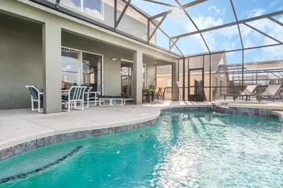 a swimming pool with chairs and a house at Orlando Villa 6245: Dream Holiday Villa in Emerald Island in Kissimmee