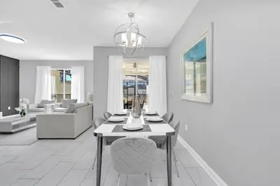 a white living room with a table and chairs at Orlando Villa 6247: Relax in Style at Storey Lake Resort in Kissimmee