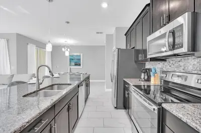a kitchen with a sink and a refrigerator at Orlando Villa 6247: Relax in Style at Storey Lake Resort in Kissimmee