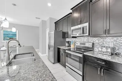 a kitchen with stainless steel appliances and a sink at Orlando Villa 6247: Relax in Style at Storey Lake Resort in Kissimmee