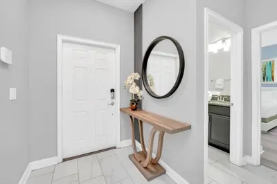 a white hallway with a mirror and a table at Orlando Villa 6247: Relax in Style at Storey Lake Resort in Kissimmee