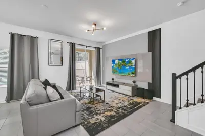 a living room with a couch and a tv at Luxury Villa at Storey Lake Resort Near Disney – Orlando Villa 6253 in Kissimmee