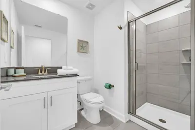 a white bathroom with a toilet and a shower at Luxury Villa at Storey Lake Resort Near Disney – Orlando Villa 6253 in Kissimmee
