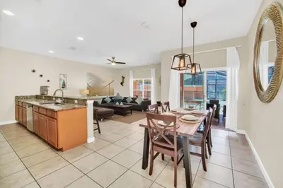 a kitchen and living room with a table and chairs at Orlando Villa 6256: Experience 5-Star Luxury at Paradise Palms Resort in Kissimmee