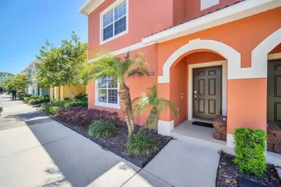 a orange building with palm trees in front of it at Orlando Villa 6256: Experience 5-Star Luxury at Paradise Palms Resort in Kissimmee