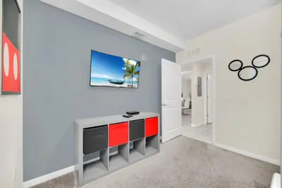 a living room with a tv on a wall at Orlando Condo 6259: Ultimate Family Retreat on Storey Lake in Kissimmee