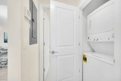 a white kitchen with a door and a sink at Orlando Condo 6259: Ultimate Family Retreat on Storey Lake in Kissimmee