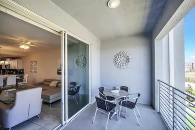 a room with a balcony with a table and chairs at Orlando Condo 6259: Ultimate Family Retreat on Storey Lake in Kissimmee