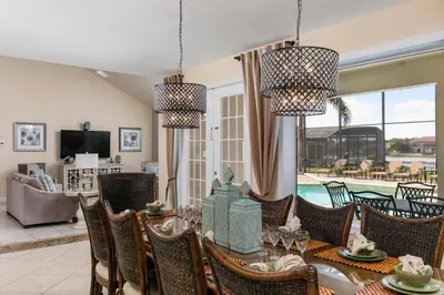 a dining room with a table and chairs and a pool at 5 Star Mansion with Private Pool on Formosa Gardens Orlando Manion 5075 in Orlando