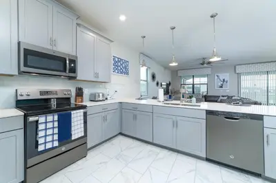 a white kitchen with white cabinets and appliances at The Ultimate Mansion with Private Pool on Storey Lake Resort Orlando Mansion 5287 in Kissimmee
