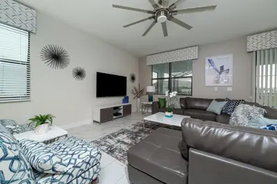 a living room with a couch and a flat screen tv at The Ultimate Mansion with Private Pool on Storey Lake Resort Orlando Mansion 5287 in Kissimmee
