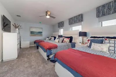 a bedroom with three beds and a ceiling fan at The Ultimate Mansion with Private Pool on Storey Lake Resort Orlando Mansion 5287 in Kissimmee