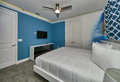 a bedroom with a white bed and a blue wall at 5 Star Mansion with Private Pool on Veranda Palms Orlando Mansion 5377 in Kissimmee