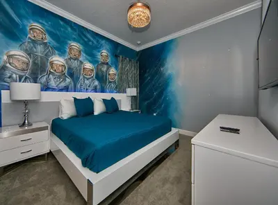 a bedroom with a mural of astronauts on the wall at 5 Star Mansion with Private Pool on Veranda Palms Orlando Mansion 5377 in Kissimmee