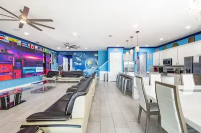 a dining room with chairs and a kitchen with blue walls at Exclusive Mansion with Large Private Pool on Veranda Palms Orlando Mansion 5378 in Kissimmee