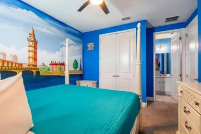 a bedroom with a blue bed with a clock tower at Exclusive Mansion with Large Private Pool on Veranda Palms Orlando Mansion 5378 in Kissimmee