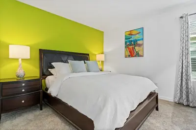 a bedroom with a bed and a green wall at Beautiful Mansion with first class amenities on Solara Resort Orlando Mansion 5715 in Orlando