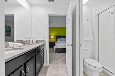 a bathroom with a sink and a toilet and a bedroom at Beautiful Mansion with first class amenities on Solara Resort Orlando Mansion 5715 in Orlando