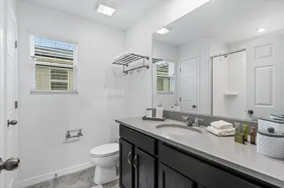 a white bathroom with a sink and a toilet at Beautiful Mansion with first class amenities on Solara Resort Orlando Mansion 5715 in Orlando