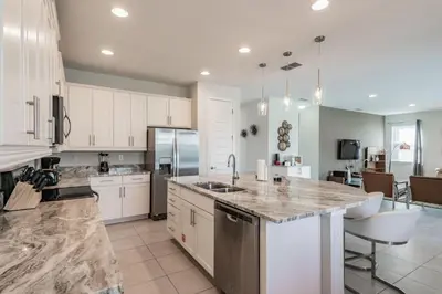 a large kitchen with white cabinets and a counter top at Rent the Perfect 5 Bedroom Villa Encore Resort Villa 6416 in Orlando