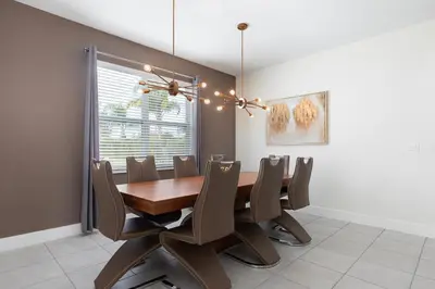 a dining room with a wooden table and chairs at Rent the Perfect 5 Bedroom Villa Encore Resort Villa 6416 in Orlando