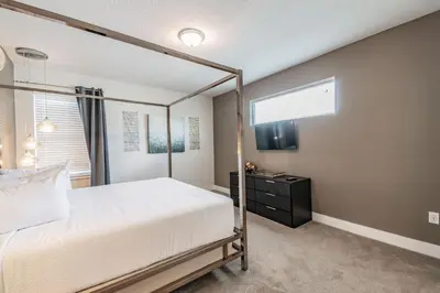 a bedroom with a canopy bed and a black dresser at Rent the Perfect 5 Bedroom Villa Encore Resort Villa 6416 in Orlando