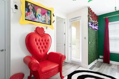 a red heart chair in a room with green walls at Unleash Your Dreams in a Magical Getaway in Orlando
