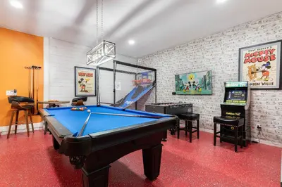a room with a pool table and a video game at Unleash Your Dreams in a Magical Getaway in Orlando