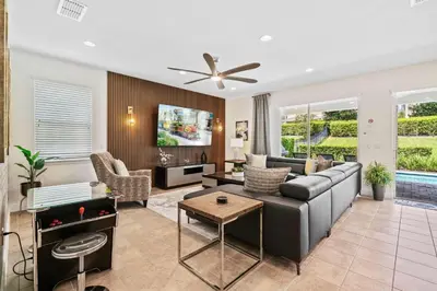 a living room with a couch and a ceiling fan at Experience Magic and Luxury Just Minutes from Disney in Orlando