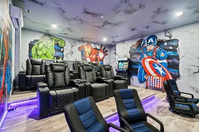 a room with a gaming room with superheroes on the wall at Experience Magic and Luxury Just Minutes from Disney in Orlando