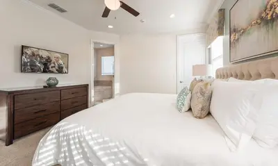 a bedroom with a large white bed and a dresser at Dive into Luxury and Fun at Your Orlando Paradise in Orlando