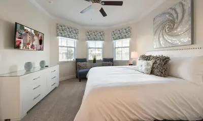 a bedroom with a large bed with a ceiling fan at Dive into Luxury and Fun at Your Orlando Paradise in Orlando