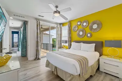 a bedroom with a large bed and a yellow wall at Indulge in Opulence: Where Comfort Meets Endless Fun in Orlando