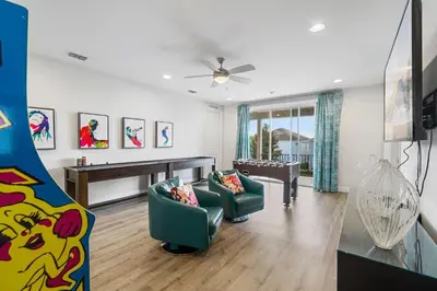 a living room with two green chairs and a piano at Indulge in Opulence: Where Comfort Meets Endless Fun in Orlando