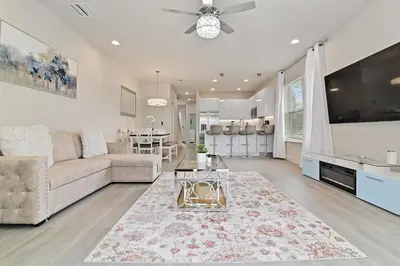 a living room with a couch and a tv at New Luxury Dream Vacation Home With Gym, 70 inch TV, Private Pool, 4 Bedrooms, 3 Full Baths, High Speed WiFi in Orlando