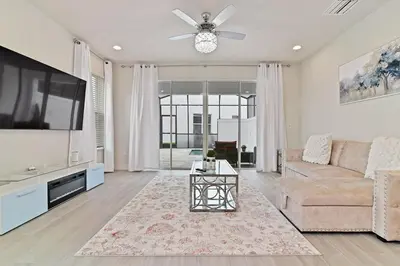 a living room with a couch and a flat screen tv at New Luxury Dream Vacation Home With Gym, 70 inch TV, Private Pool, 4 Bedrooms, 3 Full Baths, High Speed WiFi in Orlando