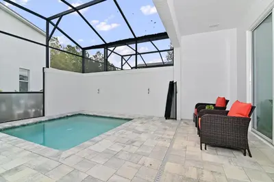 a swimming pool in a house with glass windows at New Luxury Dream Vacation Home With Gym, 70 inch TV, Private Pool, 4 Bedrooms, 3 Full Baths, High Speed WiFi in Orlando