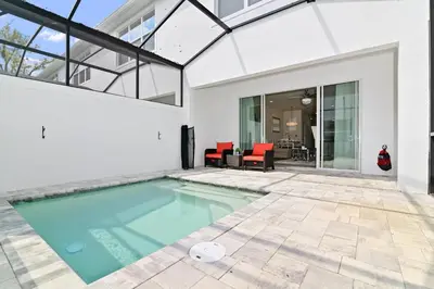 a swimming pool in the backyard of a house at New Luxury Dream Vacation Home With Gym, 70 inch TV, Private Pool, 4 Bedrooms, 3 Full Baths, High Speed WiFi in Orlando