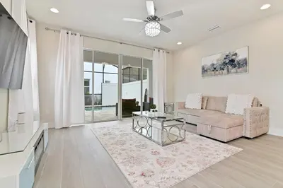a living room with a couch and a table at New Luxury Dream Vacation Home With Gym, 70 inch TV, Private Pool, 4 Bedrooms, 3 Full Baths, High Speed WiFi in Orlando