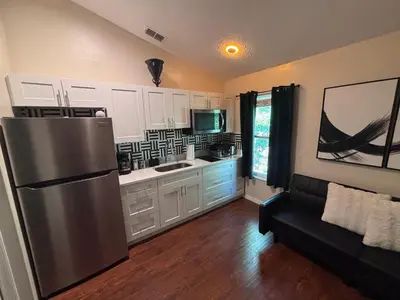 a kitchen with a stainless steel refrigerator and a couch at Luxury Apartment with Lake view in Orlando