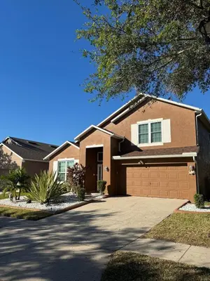 a brown house with a driveway at Luxury Apartment with Lake view in Orlando